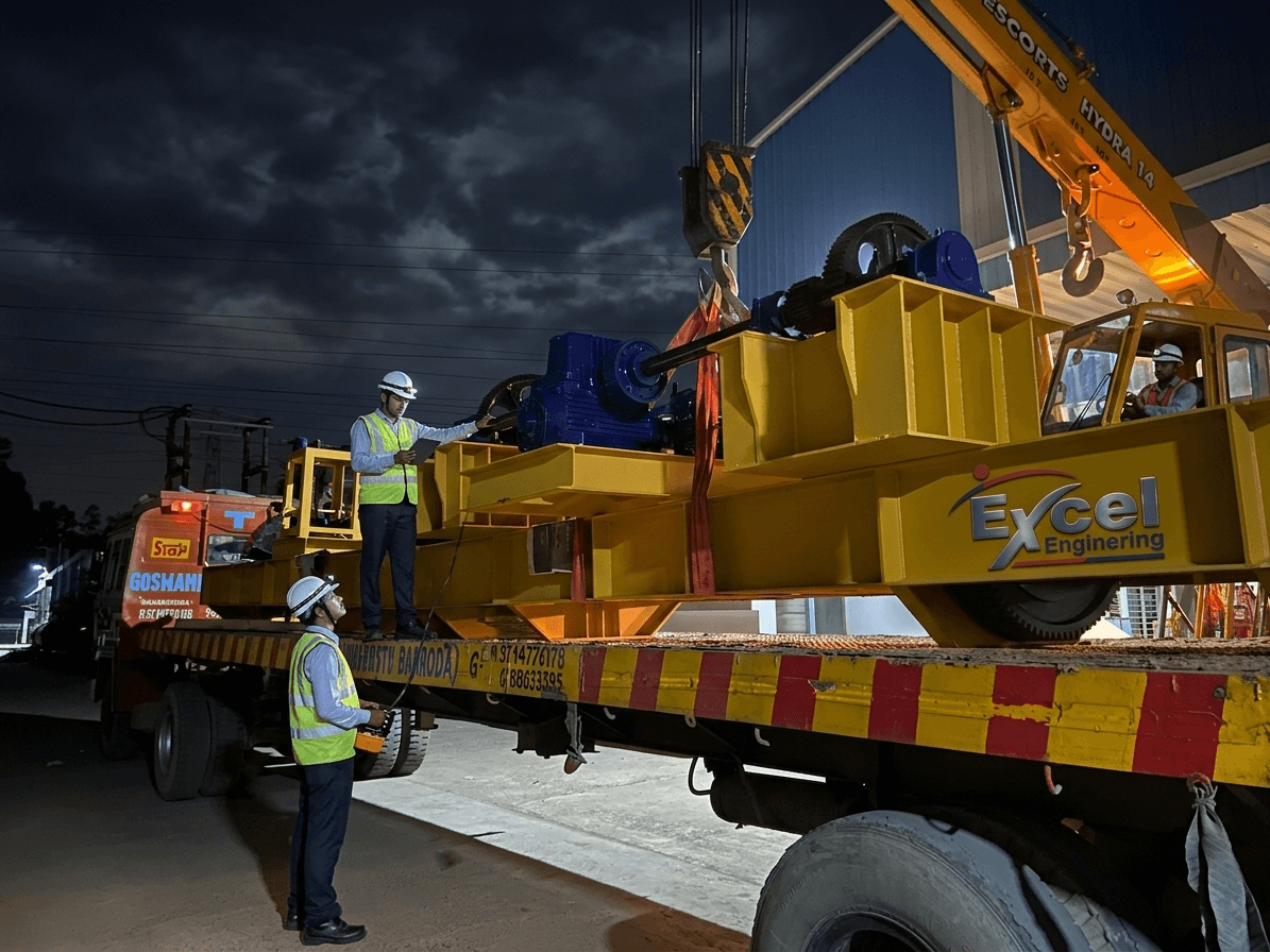 Excel Engineering crane equipment being loaded on flatbed truck at night